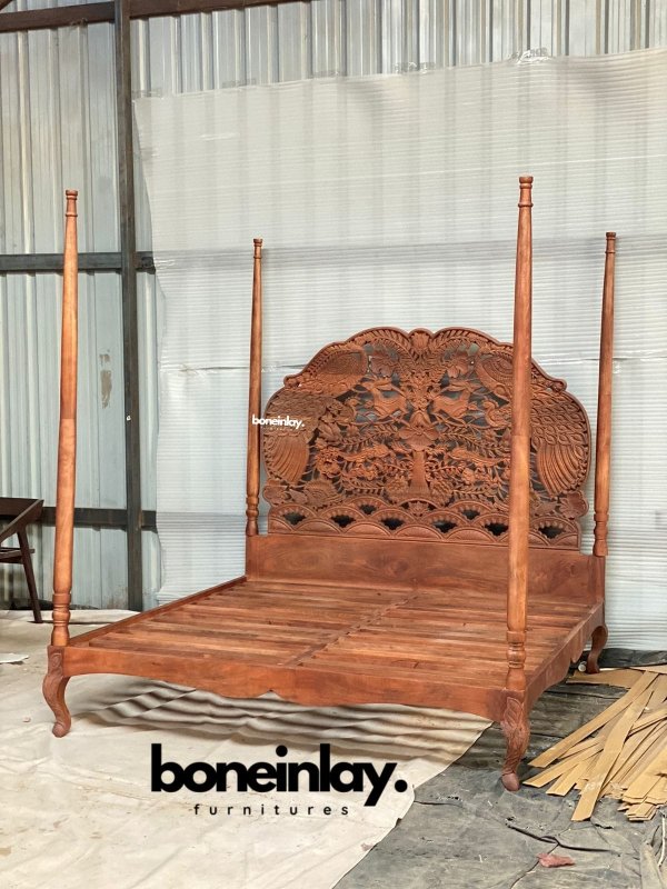 Custom Woodland four-poster bed with solid wood frame, natural finish, and hand-carved peacock and floral headboard.