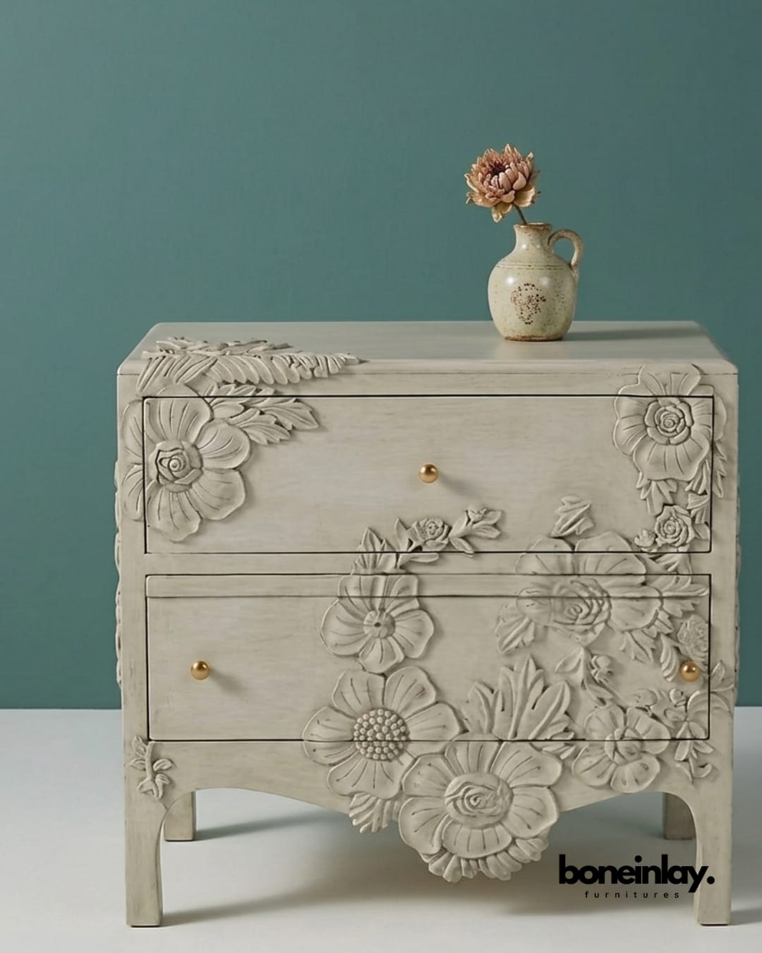 Two-drawer white bedside table with hand-etched vine motifs and gold knobs.