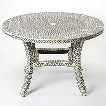 Angled view of a round gray bone inlay dining table showing its concentric leaf-patterned top and ivory-inlaid curved legs.