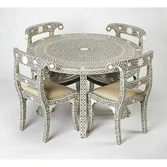 Gray and ivory floral bone inlay round dining table with four matching chairs and cream upholstered seats.