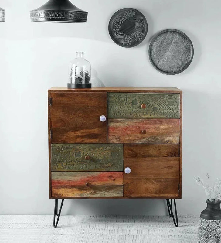 A multi-functional solid wood cabinet with a patchwork of hand-carved floral drawers and natural wood panels, supported by black metal hairpin legs.