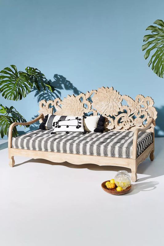 Lotus daybed featuring an open slatted seat and ornate floral wood carving