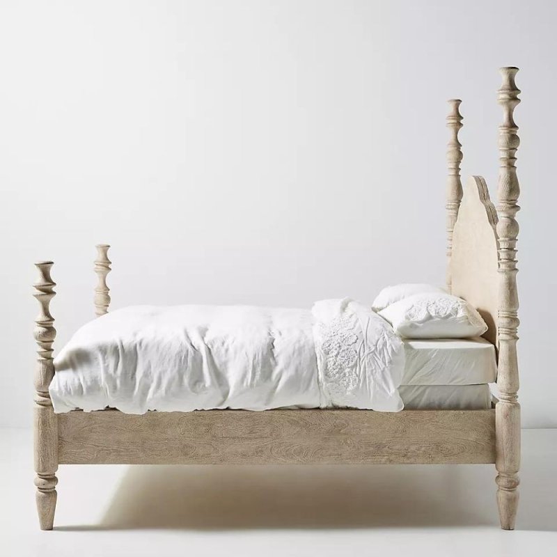 Handcrafted rustic spindle four-poster bed with high scalloped headboard, turned posts, and sturdy wooden slat support.