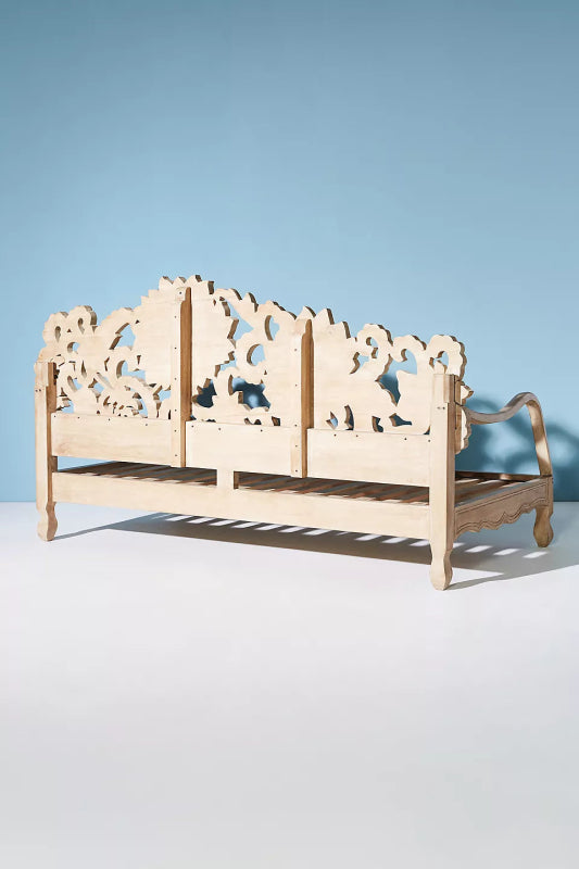 Hand-carved wooden daybed with a broad floral backrest and airy slatted seat.