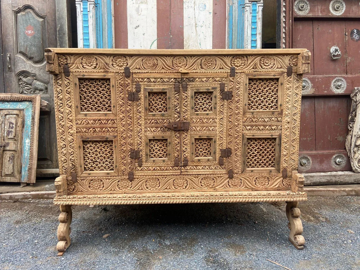  Full front view of a hand-carved wooden dowry chest with floral borders, lattice doors, and a central metal latch.