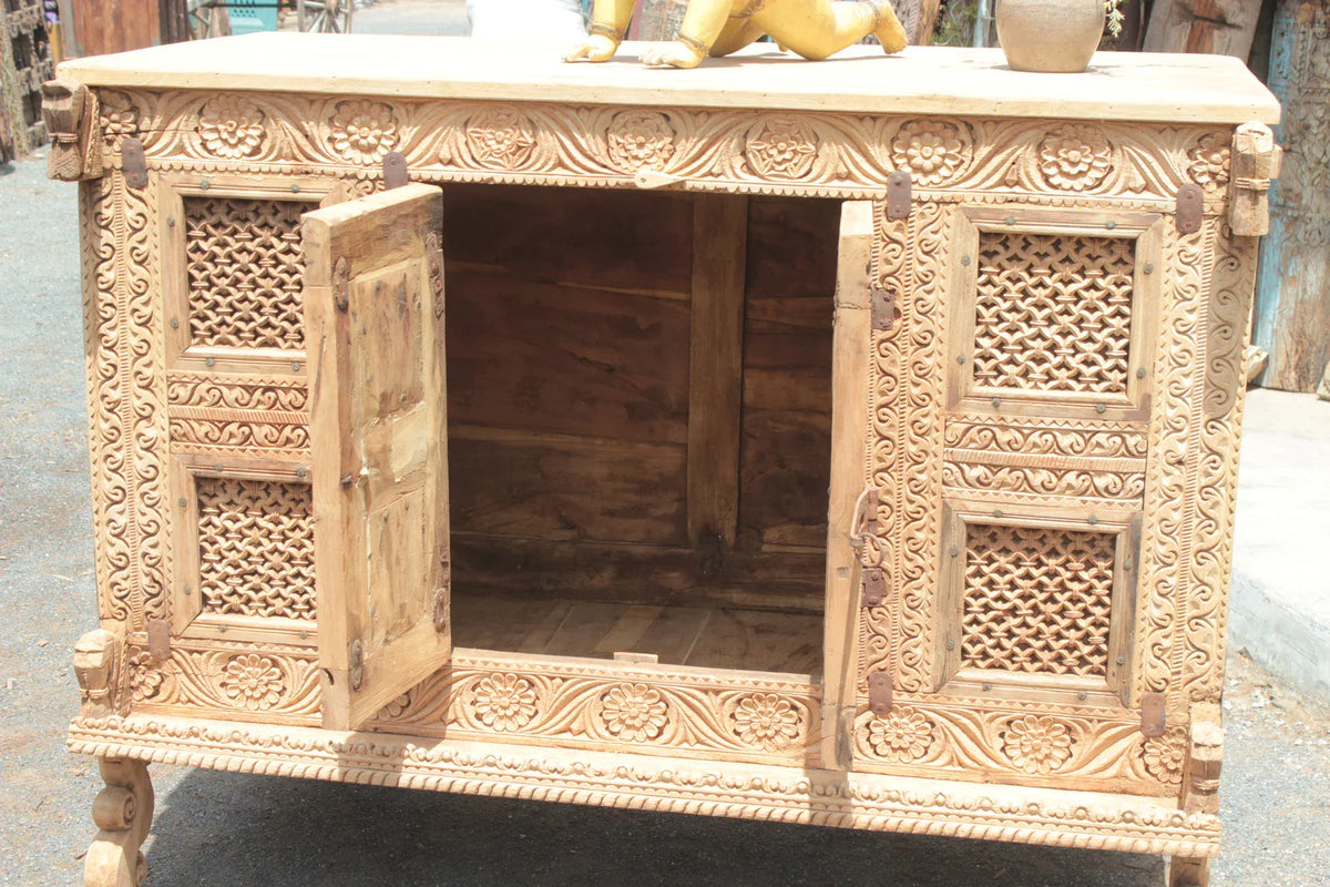 Wooden dowry chest with a central door open, revealing the storage interior behind its carved lattice front.