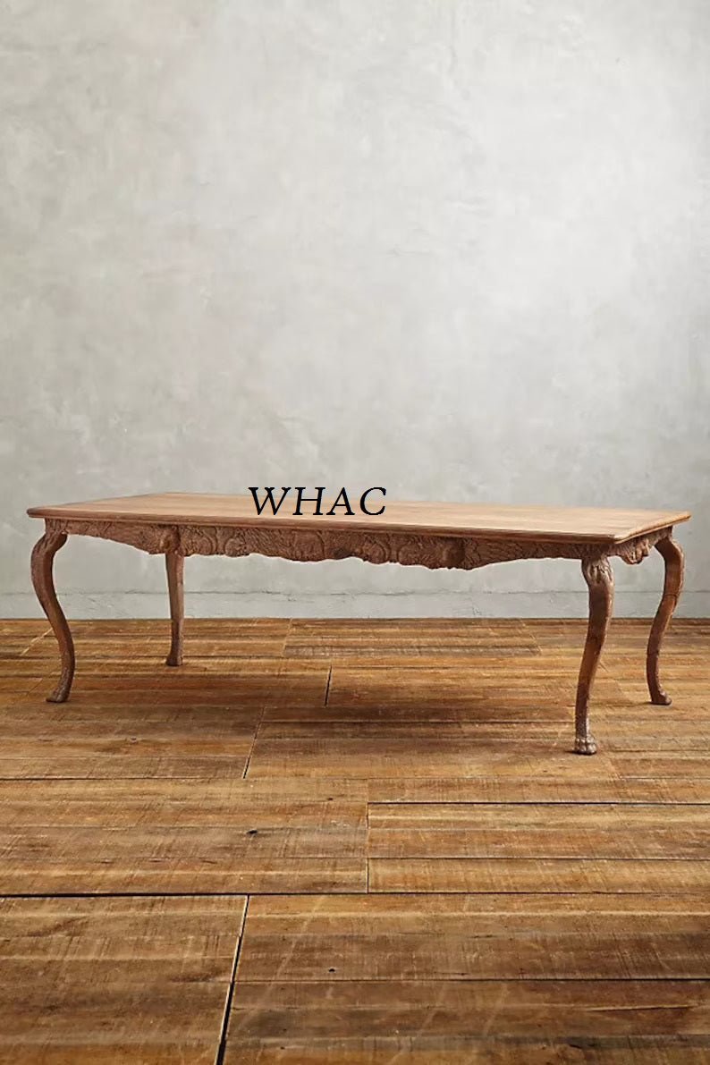 A natural wood version of the hand-carved dining table shown from a side profile, emphasizing the rich grain of the solid wood.