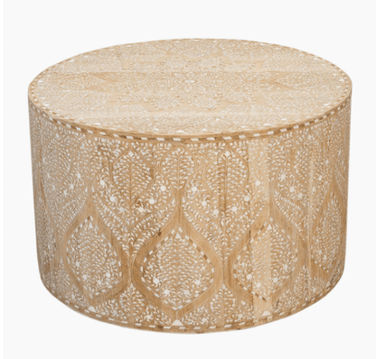 A round drum-style coffee table made of light-colored wood with white Moroccan-inspired bone inlay floral patterns covering the top and sides.