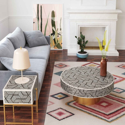Matching black and white geometric bone inlay round coffee table and square side table with brass legs styled together in a modern living room