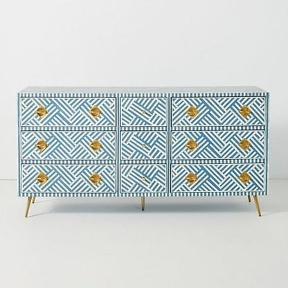 Front view of a large ocean blue and white striped bone inlay 9-drawer dresser with gold geometric knobs and tapered brass legs.