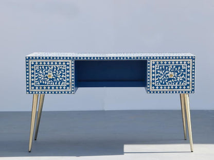 Front view of a royal blue and white floral bone inlay writing desk with gold tapered legs against a white background.