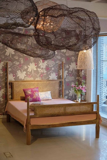 Solid wood four canopy bed with cane design and a natural-looking finish.