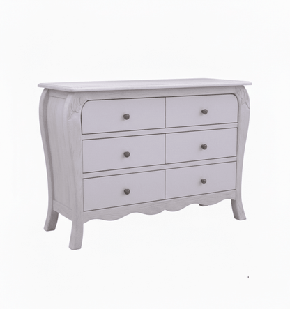 The Menagerie wide chest of drawers, designed with a sophisticated bowed front and a decorative scalloped base. The piece features six spacious drawers with classic round metal pulls and a muted lavender-grey patina that highlights the wood’s natural grain and the collection’s neo-deco influence.