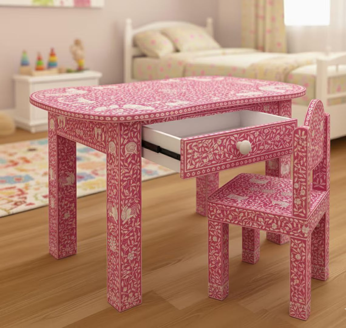  Pink bone inlay kids study desk and matching chair with floral and animal motifs in a bedroom.