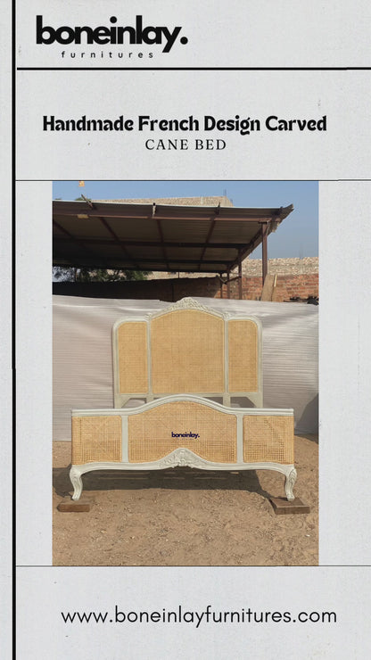 This video highlights a handcrafted French-design bed frame featuring light tan natural cane webbing inserts on both the three-panel headboard and the contoured footboard. The solid wood structure is finished in a vintage off-white hue, decorated with delicate floral crown carvings and supported by classic cabriole legs. Text overlays emphasize bespoke ordering benefits such as free worldwide delivery and customization options.