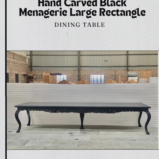This video presents a grand, large rectangular dining table finished in a sophisticated matte black. The piece is a hallmark of artisan craftsmanship, characterized by its unique "menagerie" theme featuring hand-carved animal and floral motifs.