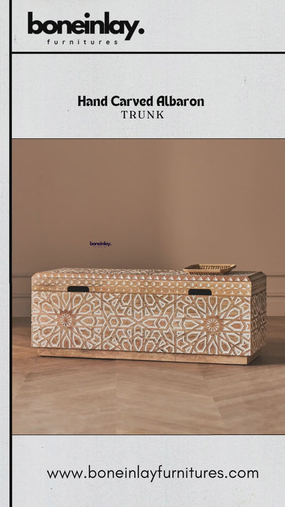 This video showcases a meticulously handcrafted Albaron trunk featuring intricate, hand-carved geometric star patterns across its solid wood exterior. The camera pans to highlight the detailed artisanal textures, smooth wooden lid, and high-quality gold-toned hinges on the spacious interior. The design blends traditional Indian craftsmanship with a sophisticated modern aesthetic, making it a versatile statement piece for storage or decor.