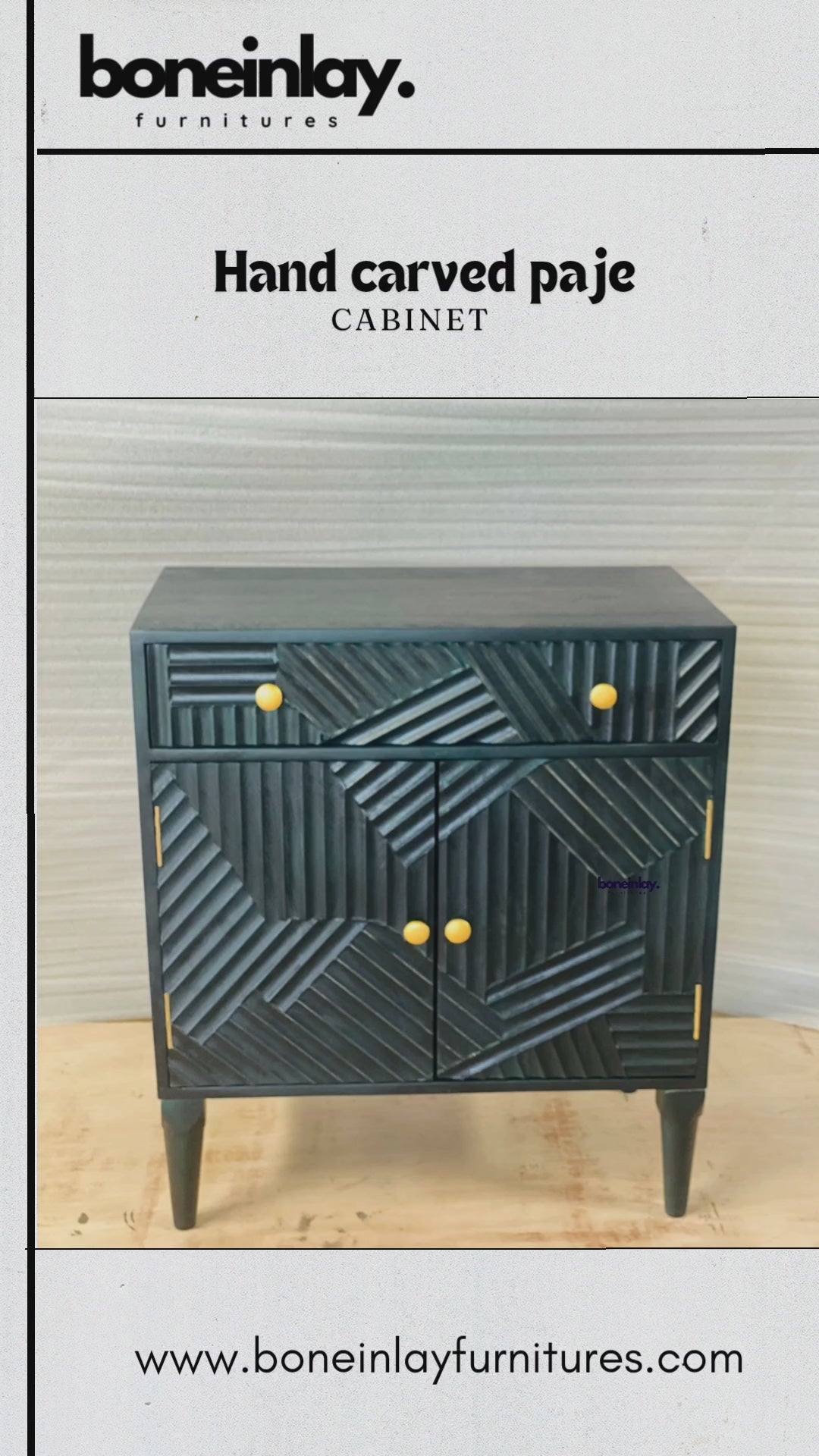 A product video showcasing a hand-carved solid wood cabinet in a deep charcoal or matte indigo finish. The piece features a striking geometric "Paje" design with multi-directional linear carvings across the drawer and doors, accented by minimalist brass-toned knobs. The video demonstrates the functional storage with a smooth-glide drawer and spacious double-door interior, standing on elegant tapered legs.