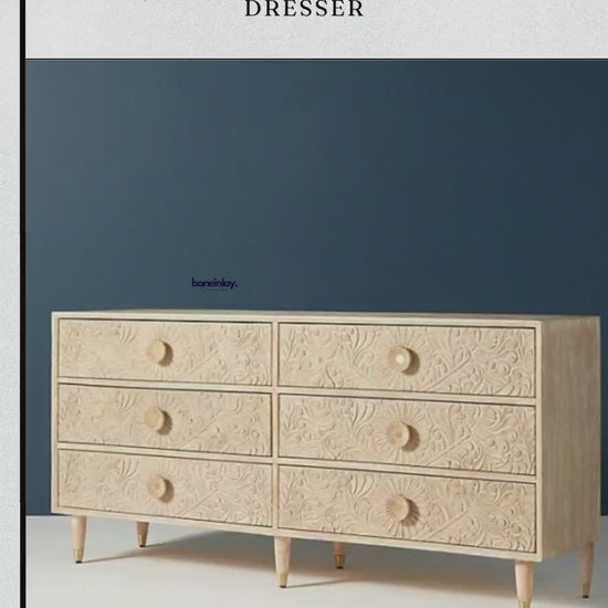 its natural, light-wood finish and intricate hand-carved floral patterns that cover the entire front surface. The video then transitions to a cinematic pan of the dresser in a workshop setting, providing a closer look at the organic texture and artisan detail.