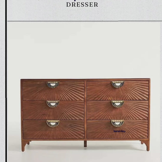 Close-up video of a solid wood Daybreak dresser featuring six spacious drawers. The camera pans over the intricate radial sunburst carvings on the drawer fronts and highlights the unique half-moon brass pulls with geometric carved details.