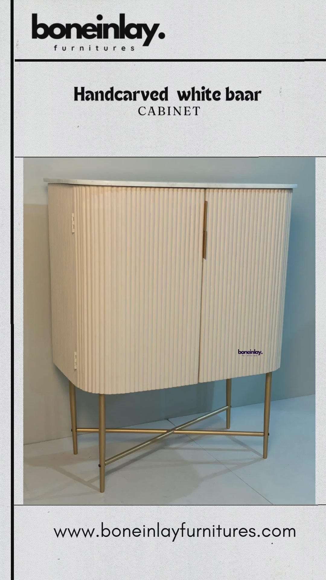 White fluted bar cabinet with rounded front corners and a brass X-leg base, shown in a branded product video.