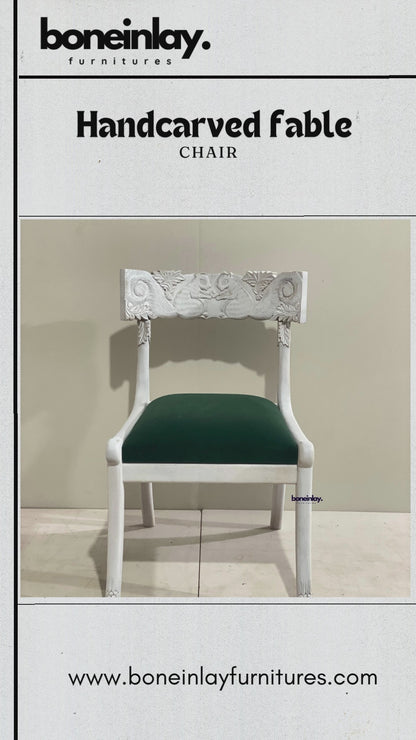 Artisan video showcasing the 'Fable' collection of hand-carved solid wood dining chairs, featuring intricate floral backrests, traditional chiseled patterns, and premium upholstered seating in a boutique workshop setting.