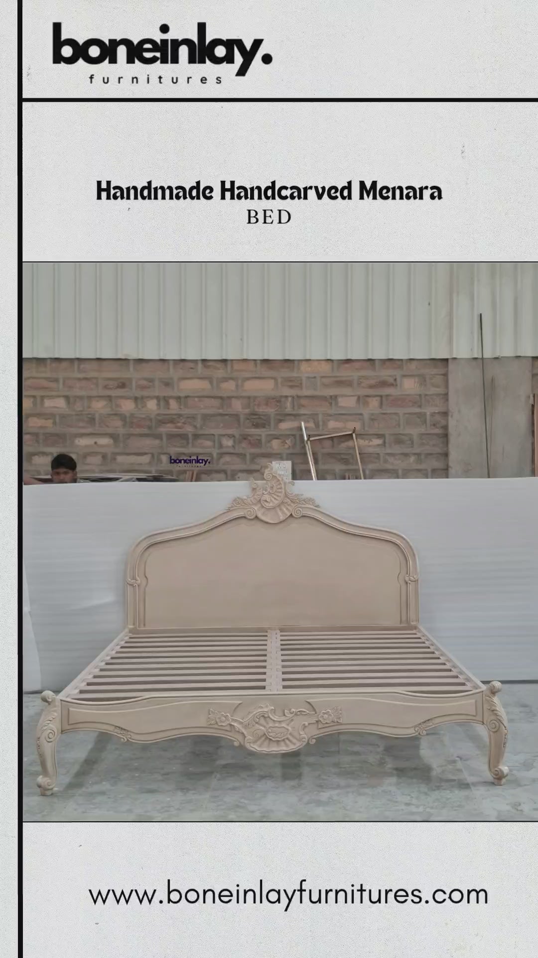 An advertisement video features a beige, handmade hand-carved wooden "Menara Bed" styled in elegant French Rococo design with an intricate shell-and-floral crest headboard, cabriole legs, and detailed relief carvings. The camera pans across the platform frame inside a spacious warehouse, highlighting the subtle color and artisan details from multiple sweeping angles. It concludes with a call-to-action screen displaying "Shop now," the website URL, and consumer incentives including free worldwide delivery an