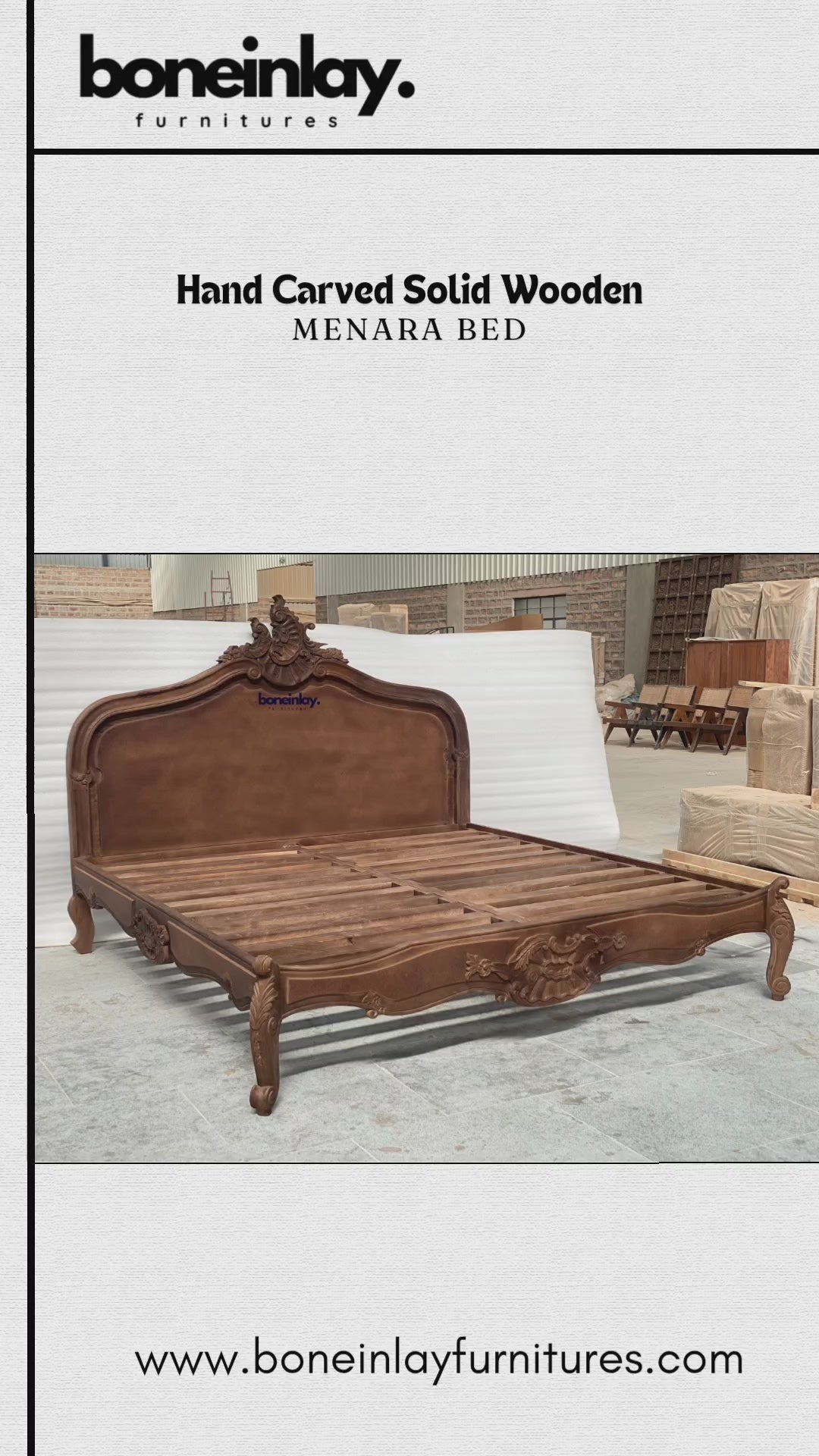 An advertisement video features a rich brown, hand-carved solid wooden "Menara Bed" styled in elegant French Rococo design with an intricate shell-and-floral crest headboard, cabriole legs, and ornate relief carvings. The camera pans across the platform frame inside a spacious warehouse, highlighting the warm wood grain and artisan details from multiple sweeping angles. It concludes with a call-to-action screen displaying "Shop now," the website URL, and consumer incentives including free worldwide delivery