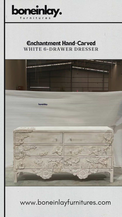 A wide, solid wood enchantment six drawers dresser in a distressed white finish, featuring six spacious drawers. The front of the piece is a masterpiece of craftsmanship, adorned with elaborate, 3D hand-carved floral sculptures that bloom across the drawer fronts and base.