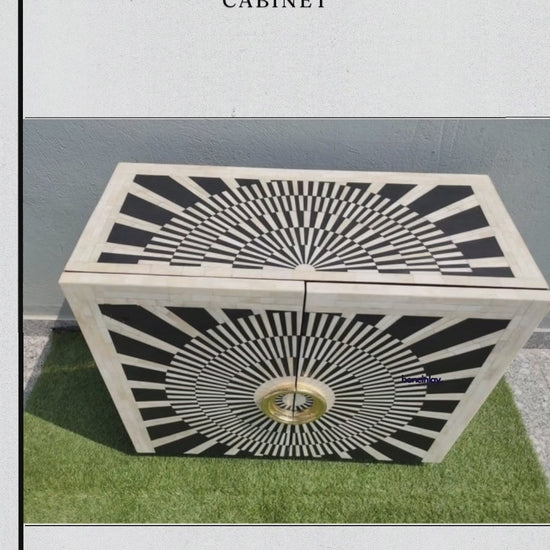 Product video featuring a black bar cabinet with optical sunburst bone inlay, two doors, and oversized circular gold-finished handles.