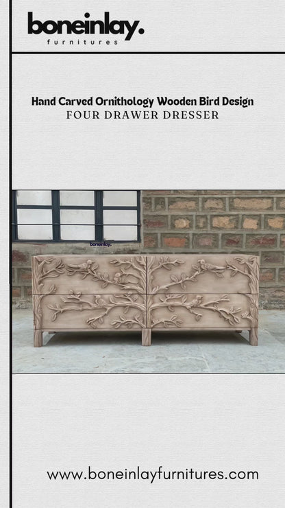 A wide, four-drawer hand-carved wooden dresser with a light natural finish. The entire front is decorated with a deeply textured 3D carving of birds on leafy tree branches. The piece has a contemporary yet rustic aesthetic with clean lines and short, square legs