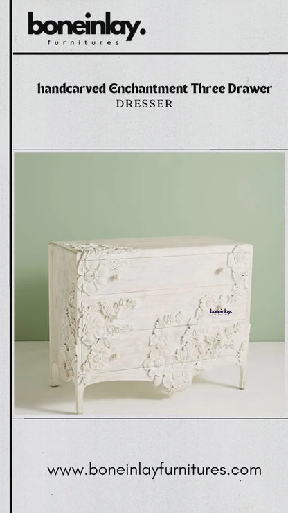 Close-up video of a hand-carved Enchantment Three Drawer Dresser in a whitewashed finish, showcasing intricate 3D floral carvings across the drawer fronts and sides. The video highlights the artisanal craftsmanship and smooth gliding drawers of this vintage-inspired solid wood furniture.