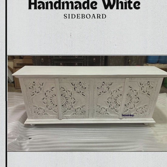 This video features a "Handmade White Sideboard" meticulously crafted from solid wood with a clean, matte white finish. The camera provides close-up views of the four cabinet doors, which are adorned with elaborate, hand-carved floral and mandala-inspired patterns. The smooth, spacious tabletop and seamless artisanal details highlight the piece's blend of traditional craftsmanship and modern functional design.