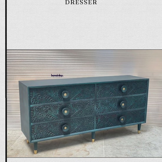 its natural, light-wood finish and intricate hand-carved floral patterns that cover the entire front surface. The video then transitions to a cinematic pan of the dresser in a workshop setting, providing a closer look at the organic texture and artisan detail.