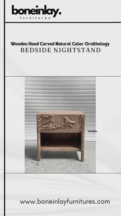 Hand-carved solid wood nightstand featuring a natural finish and an intricate ornithology relief. The single-drawer facade is masterfully sculpted with a detailed scene of birds perched on blossoming branches, doubling as a functional grip. This Bohemian-style bedside cabinet includes a spacious lower cubby and tapered legs with additional floral carvings, blending artisanal nature-inspired art with modern storage functionality.