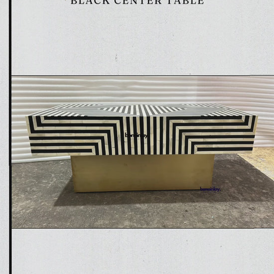 The Handmade Inlay Rectangle Stripe Black Center Table is a striking piece of furniture featuring a bold, monochromatic geometric stripe pattern on its surface. It stands on a sturdy metallic base with a gold finish, perfectly blending modern style with artisanal craftsmanship. You can shop this table and explore more unique items at www.boneinlayfurnitures.com, where they offer free worldwide delivery, customization, and secure payment options.