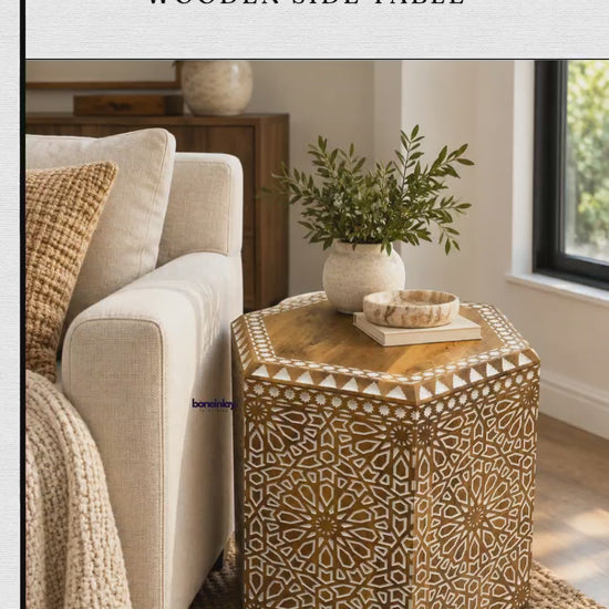 The video showcases a hand-carved Albaron hexagonal wooden side table from Bone Inlay Furnitures. The table features intricate geometric and floral patterns with a polished wooden top and decorative borders. It is displayed in a brightly lit interior setting next to a sofa and later shown independently on a stone floor.