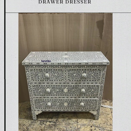 This elegant Handmade Bone Inlay Four-Drawer Dresser features a sophisticated gray finish with a classic white floral vine pattern. The unit includes two smaller top drawers and two larger bottom drawers, all accented with matching white knobs. Handcrafted with precision, the intricate design wraps around the entire piece, resting on four sturdy, decorative legs for a timeless aesthetic.
