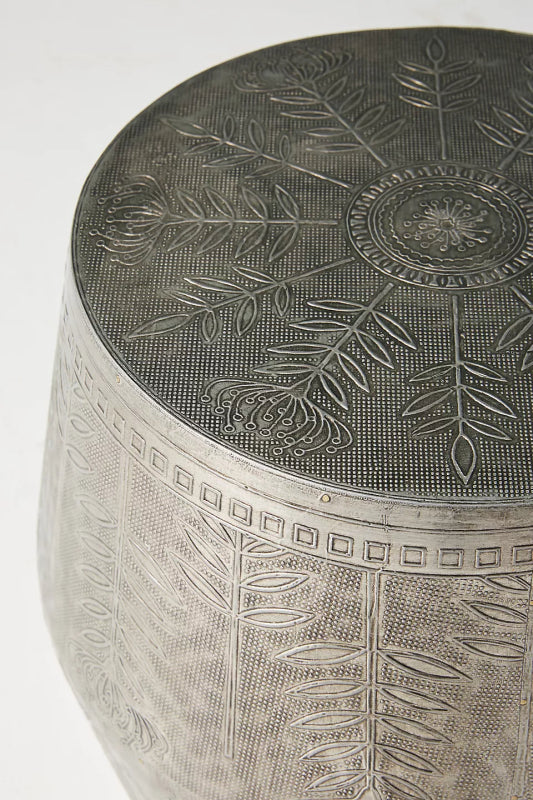 Silver round side table with embossed wildflowers, delicate vines, and a flat circular display surface.