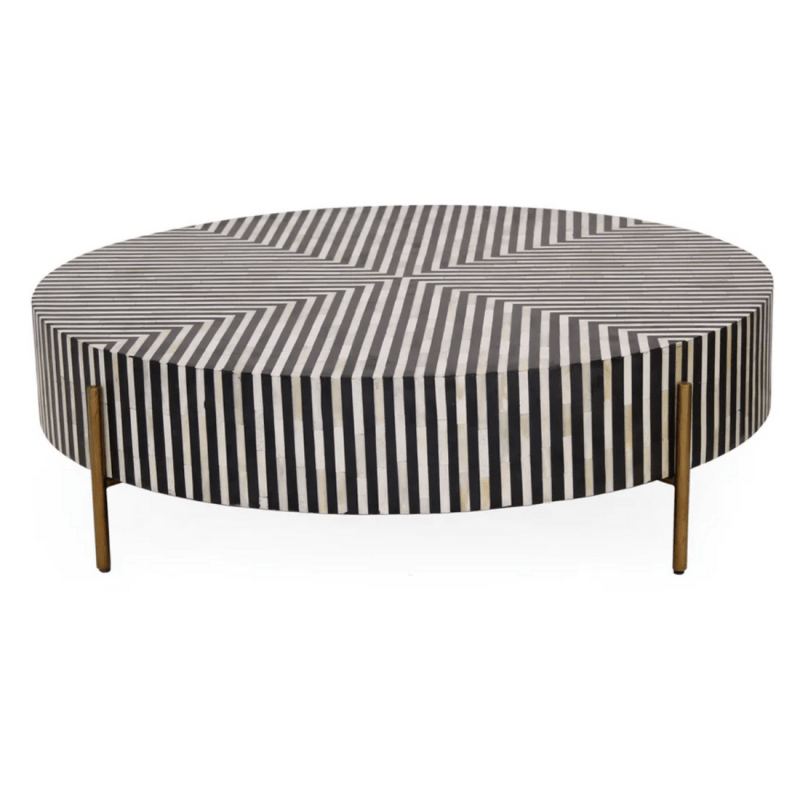 Full view of black and white geometric striped bone inlay round coffee table with mango wood body and antique brass legs on white background
