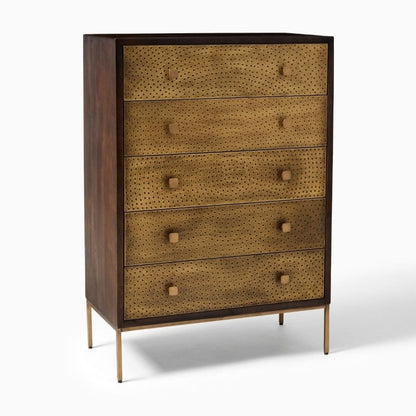 Tall Manor chest of drawers with symmetrical embossed brass panels and warm golden decorative hardware.