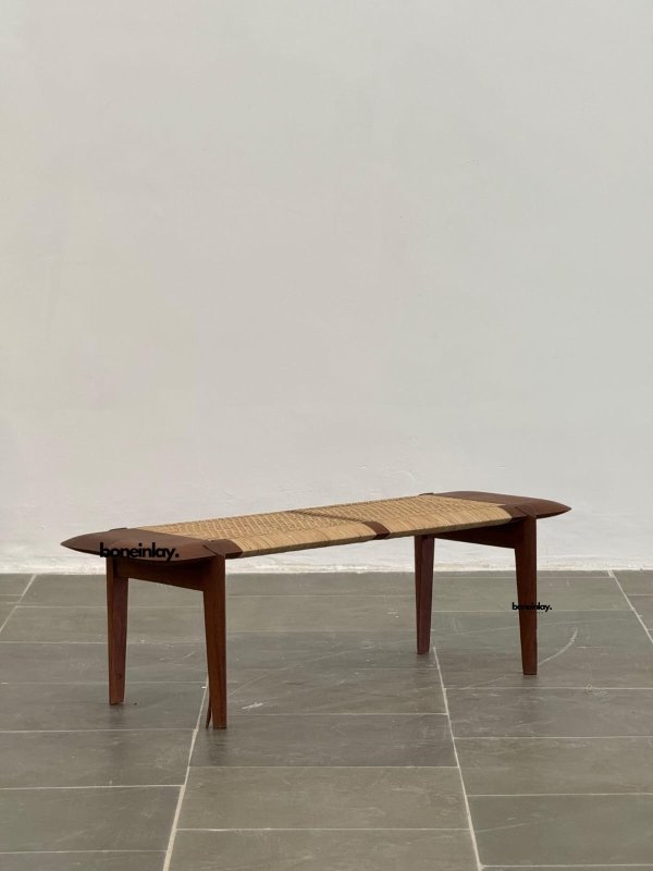 Teak wood rattan bench combining a sculptural frame, woven cane seat, and natural minimalist design.