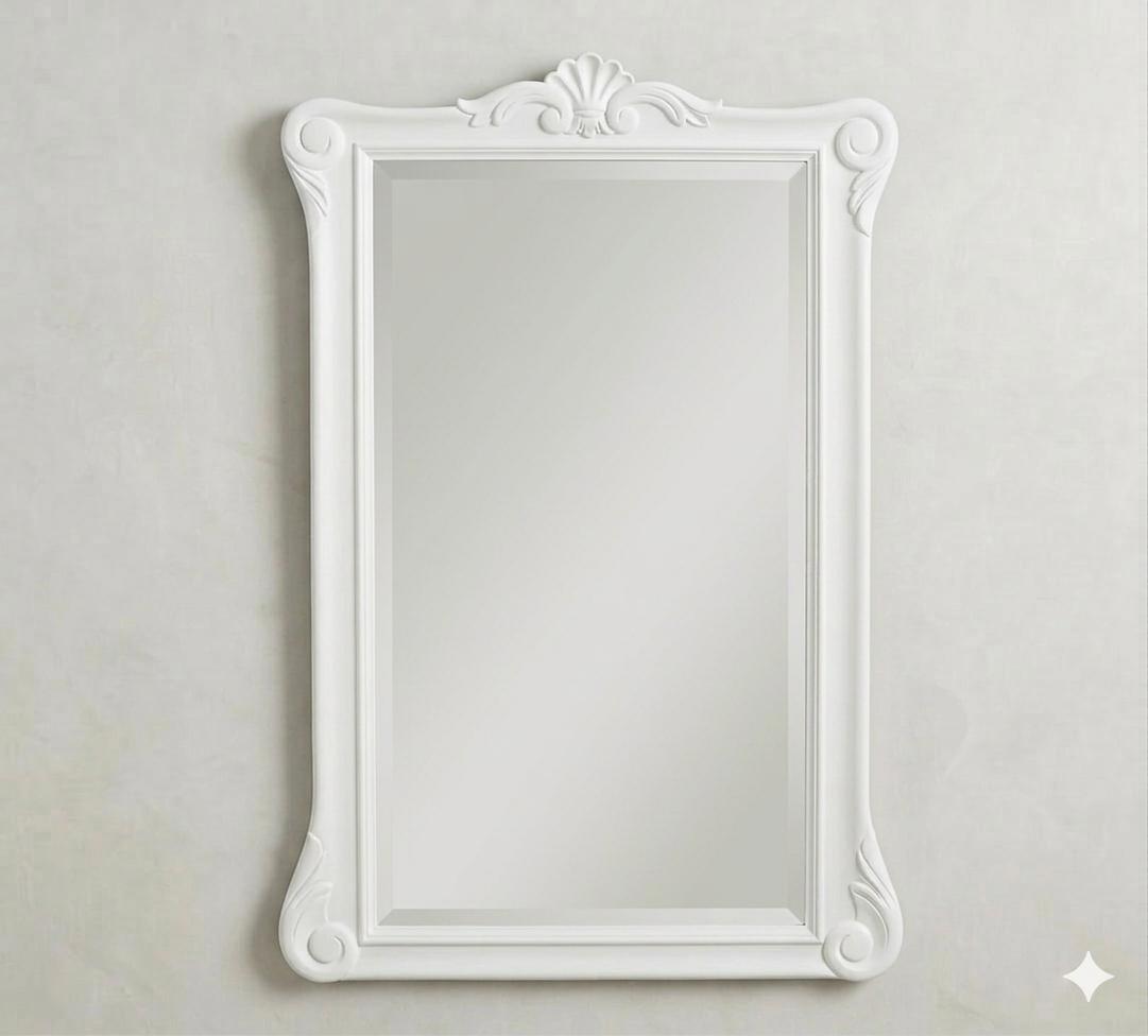 The same ornate Menara wall mirror shown in a pristine white finish, offering a softer, romantic take on the "Enchantment" design theme.
