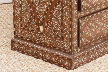 Close-up of the wood inlay dresser’s side panel and plinth base, featuring floral vines and geometric borders.