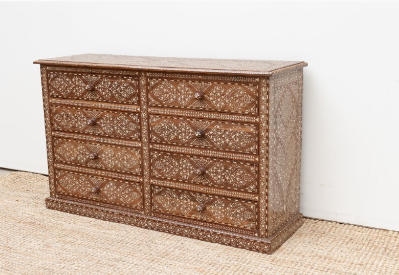 Angled view of an eight-drawer wood inlay dresser showing intricate floral patterns across the front, top, and side panel.