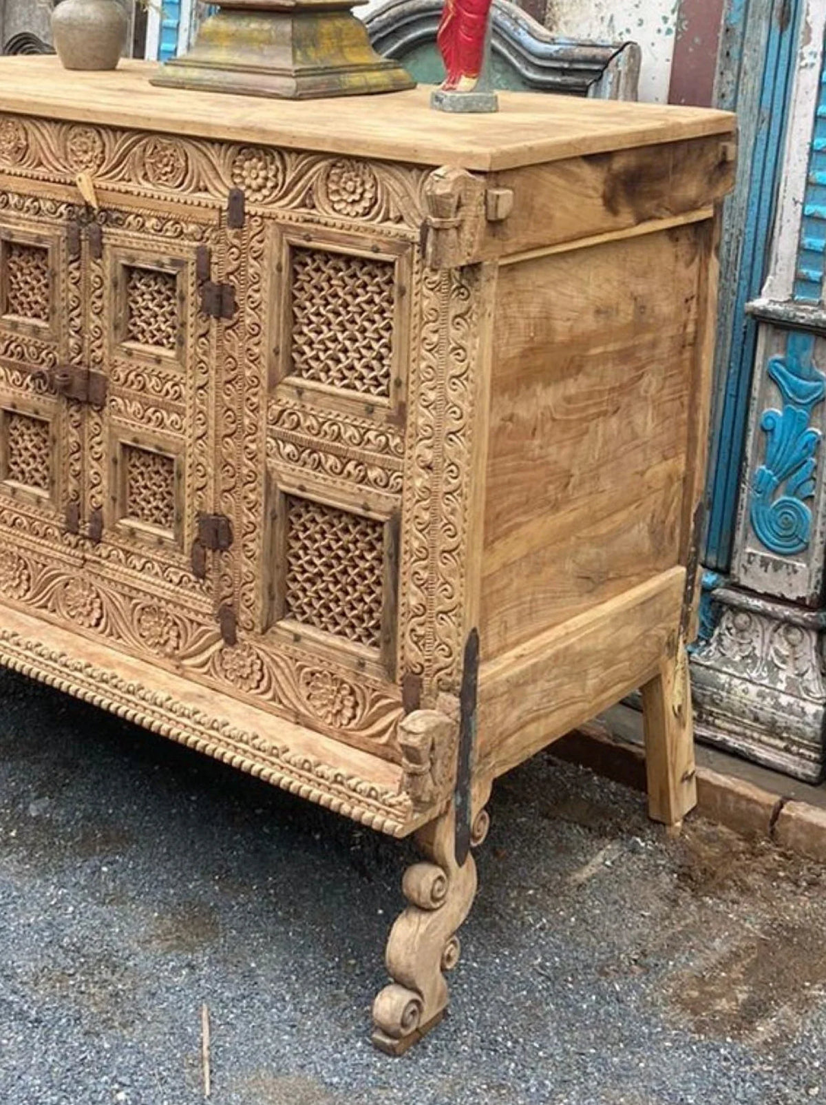 Close-up of the wooden dowry cabinet’s right side panel, lattice detailing, and curved front foot.