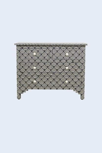 Ivory and black bone inlay bureau with four drawers, geometric fan pattern, and round ivory knobs in a three-quarter view.