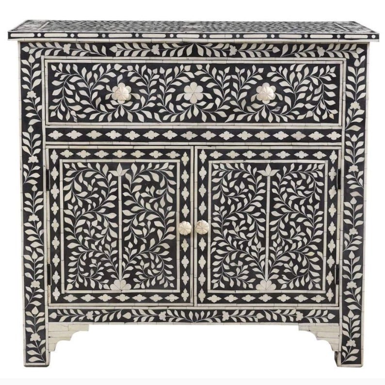 Black bone inlay storage cabinet with all-over ivory floral vine inlay, 1 drawer, 2 doors with bone knobs and diamond border, white background