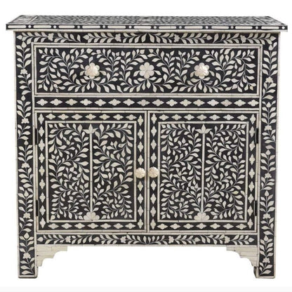 Black bone inlay storage cabinet with all-over ivory floral vine inlay, 1 drawer, 2 doors with bone knobs and diamond border, white background