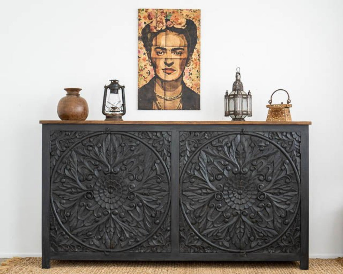 Black Floral Wood Buffet in front view, with a natural wood top, lanterns and pottery beneath a colorful portrait.